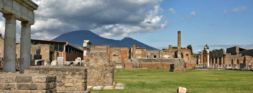 View of the ruins of Pompeii from inside the Forum with the Jewish Temple in the center, the Granary to the left and the Market to the right and Mount Vesuvius in the background.